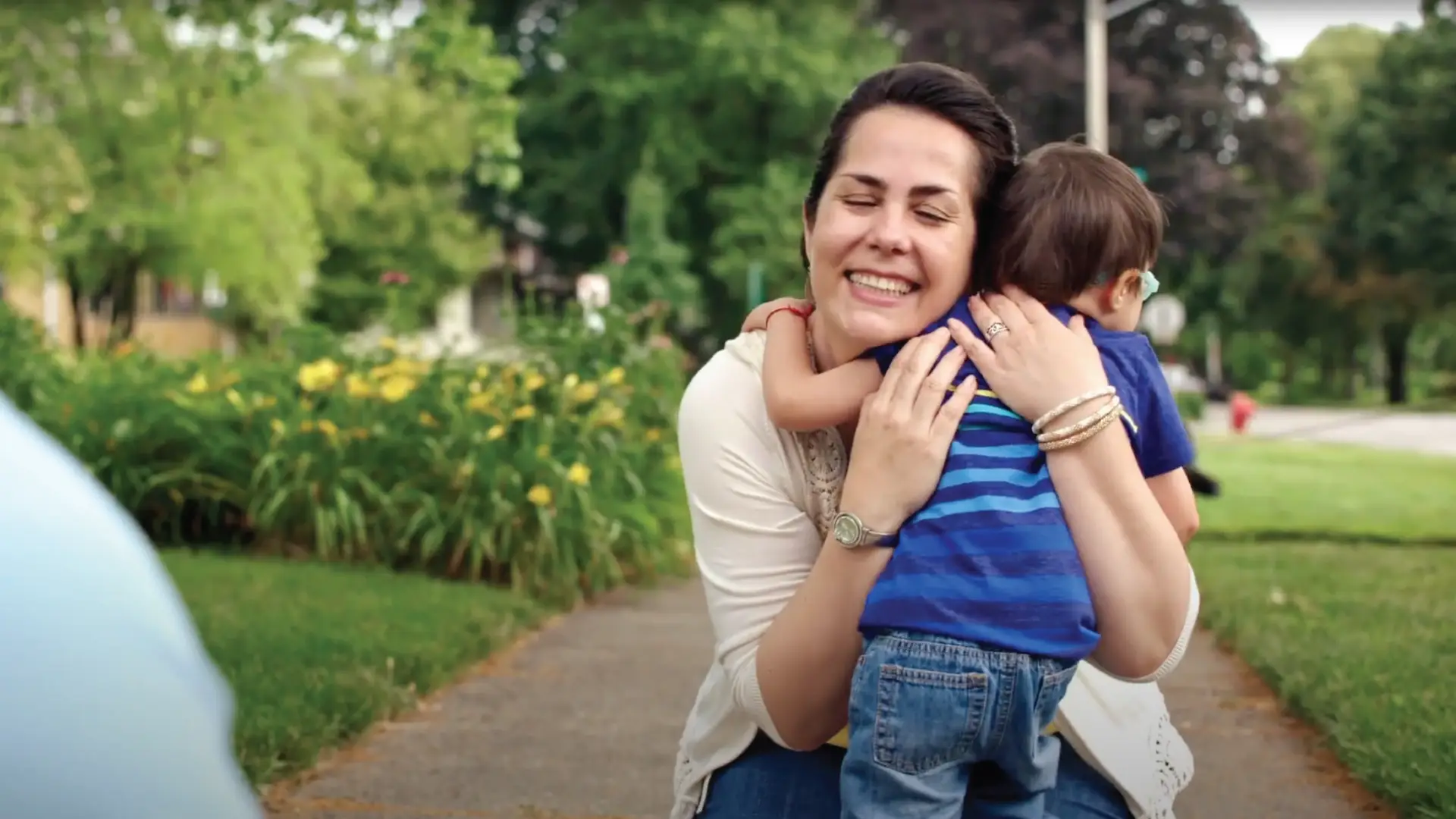 mother holding her son tightly playing outside